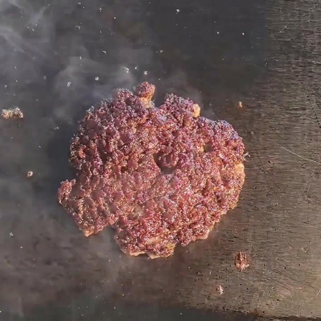 Una fetta di formaggio che si scioglie sopra un burger di manzo succoso.