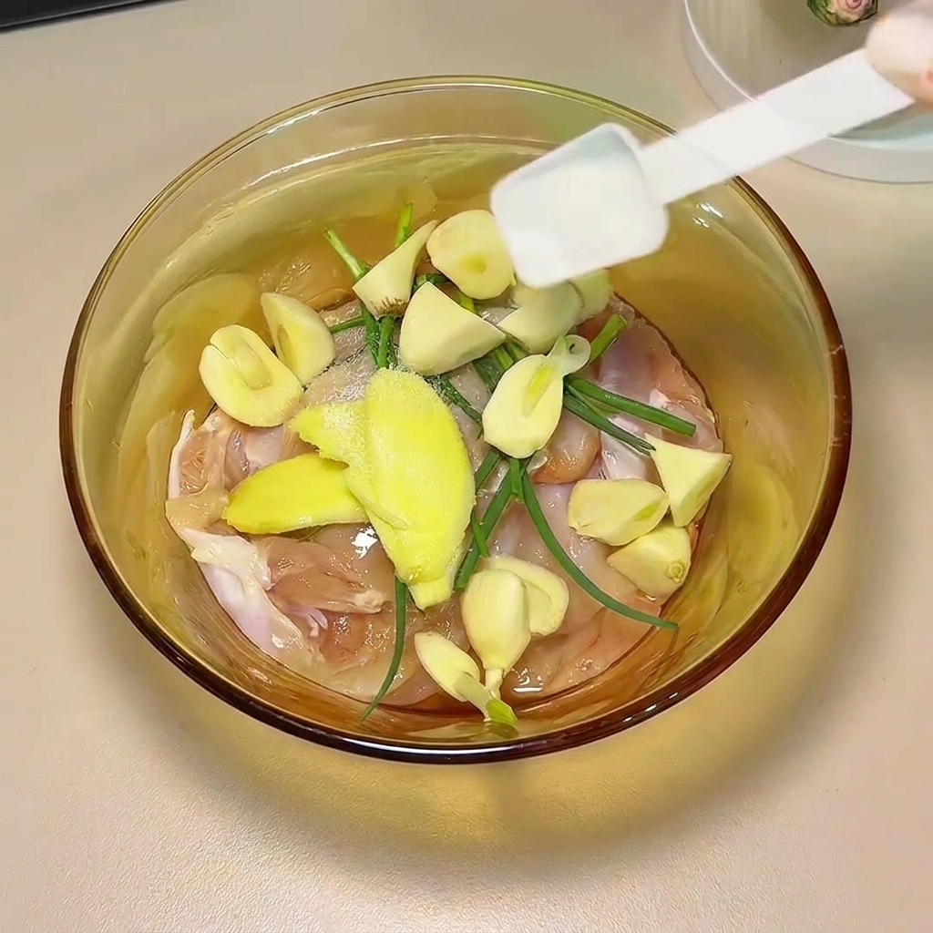 Salsa di soia e spezie versate sulle cosce di pollo e gli aromi in una ciotola di vetro.