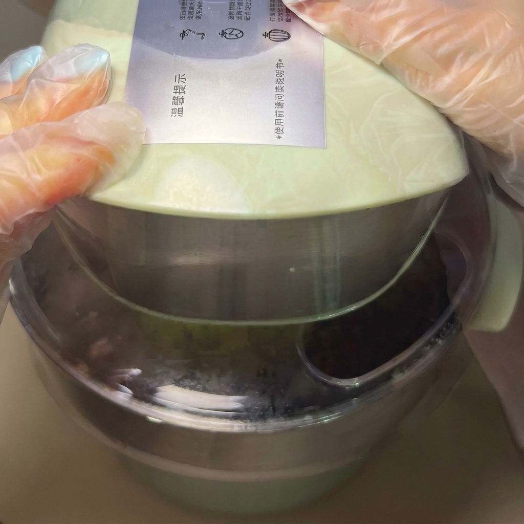 Mani che modellano una porzione di impasto in una pallina liscia e rotonda.