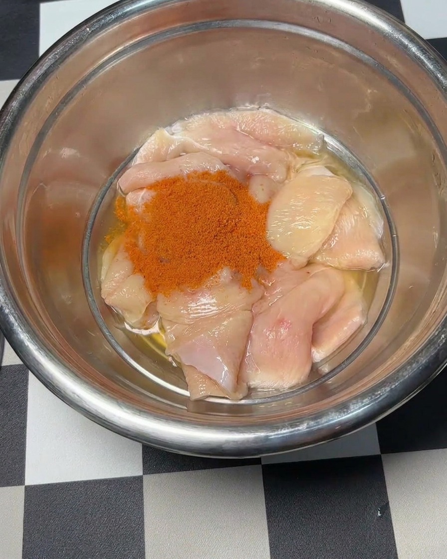 Polvere per marinata rossa di Orleans versata sopra i pezzi di pollo.