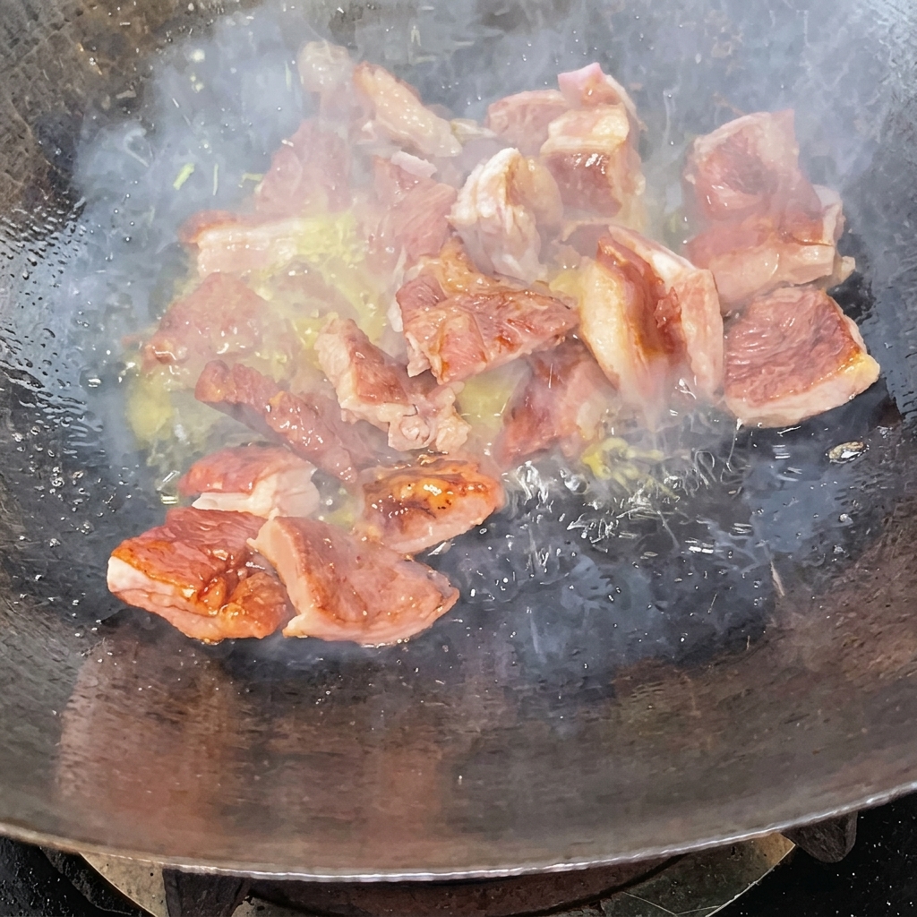 Pezzi di costine saltati in un wok ricoperti di glassa al caramello scuro.