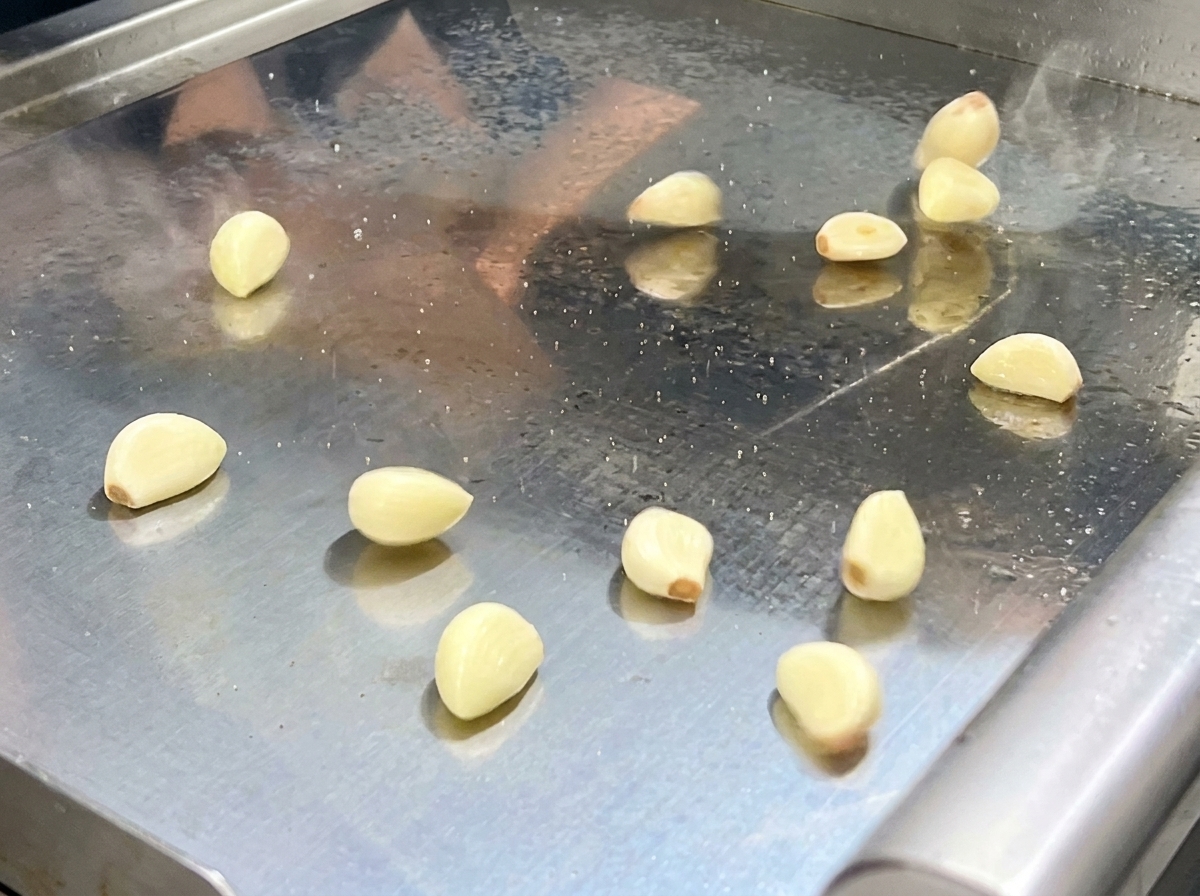 Il composto di peperoncini e aromi saltati versato nel contenitore di un robot da cucina.