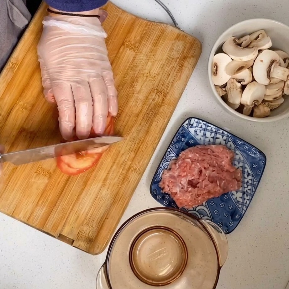 Un pomodoro sbucciato tagliato a cubetti su un tagliere di legno.