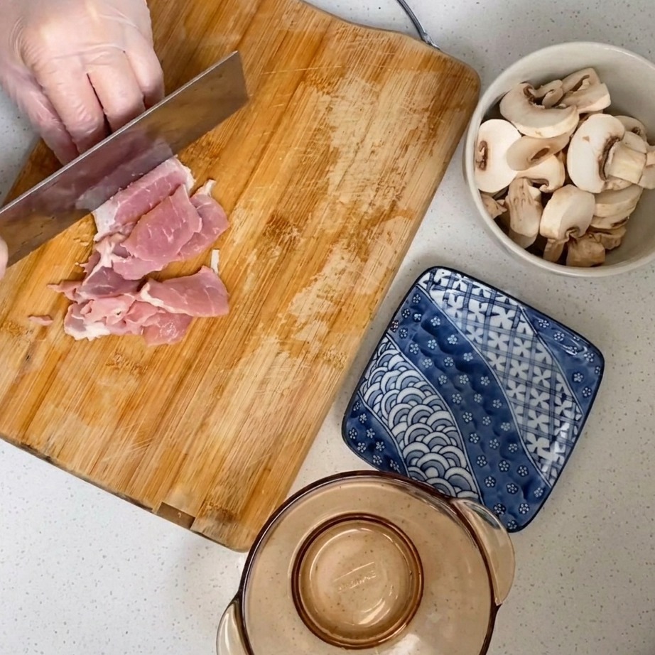 Carne di maiale cruda tritata finemente su un tagliere di legno.