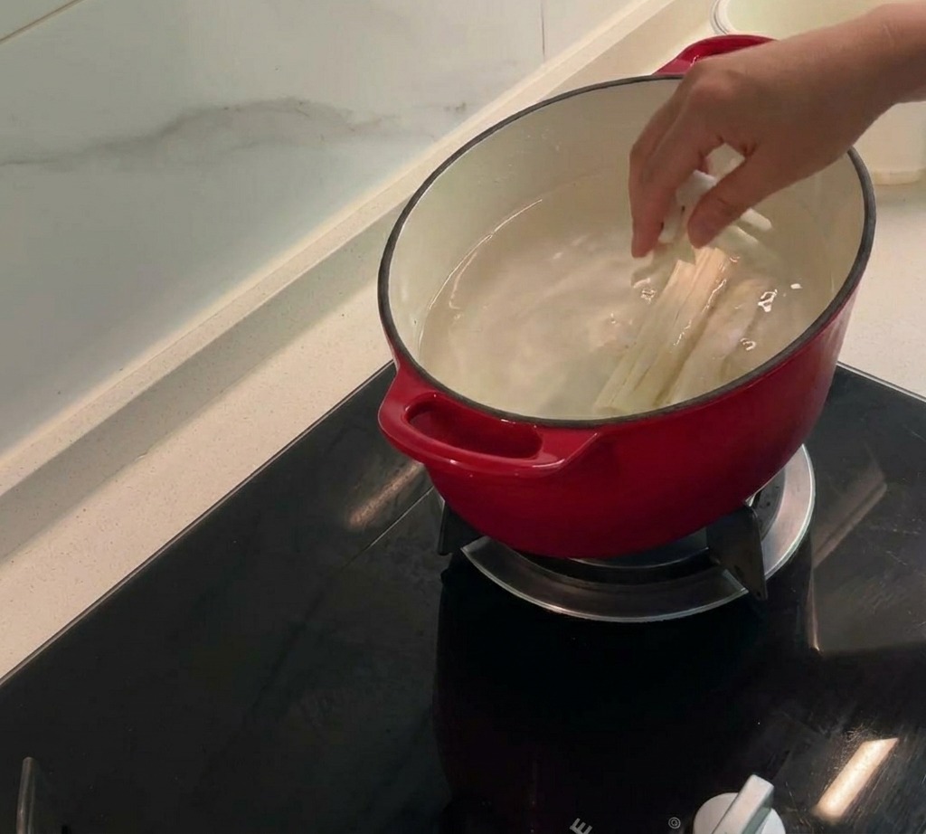Barbe di mais, tutoli e pelli di pollo che sobbollono in una pentola dacqua per creare un brodo saporito.