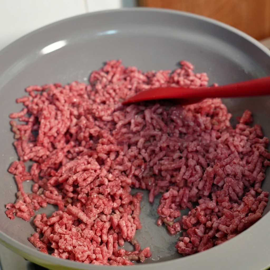 Carne di manzo macinata mescolata in una padella, con un aspetto ben rosolato.