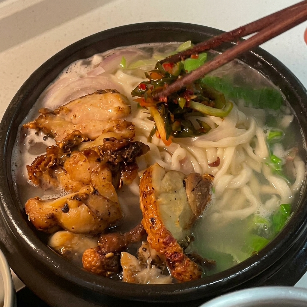 Vivace kimchi di cipollotto rosso aggiunto come guarnizione sopra la zuppa di noodles al pollo.