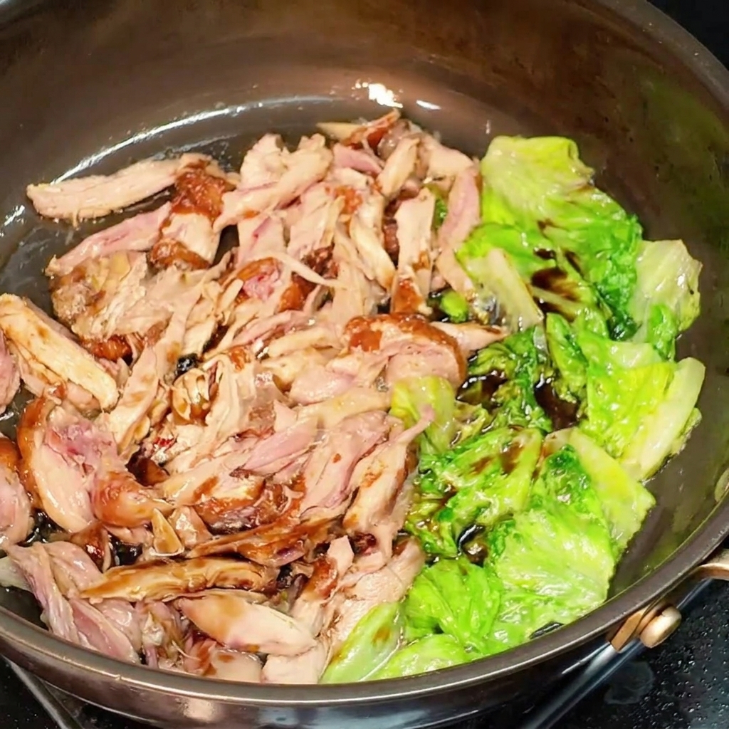 Pollo e lattuga conditi con salsa di soia in padella.