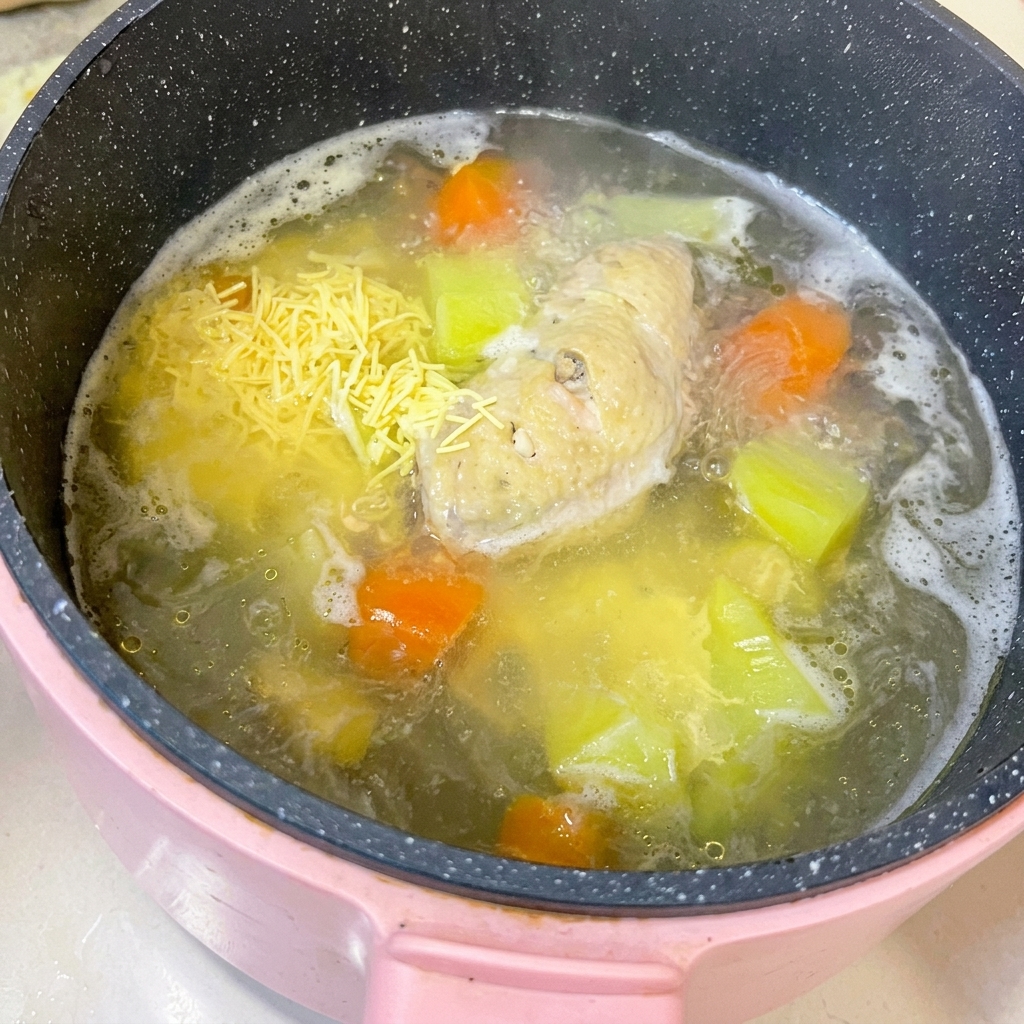 Ali di pollo cotte su un tagliere con la carne separata dallosso usando un coltello da cucina.