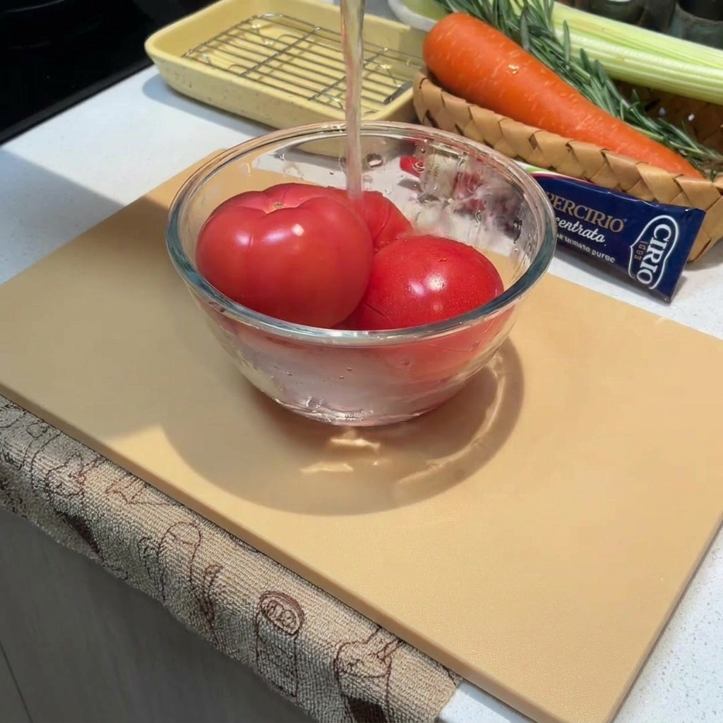 Pomodori interi in una ciotola coperti da acqua calda.