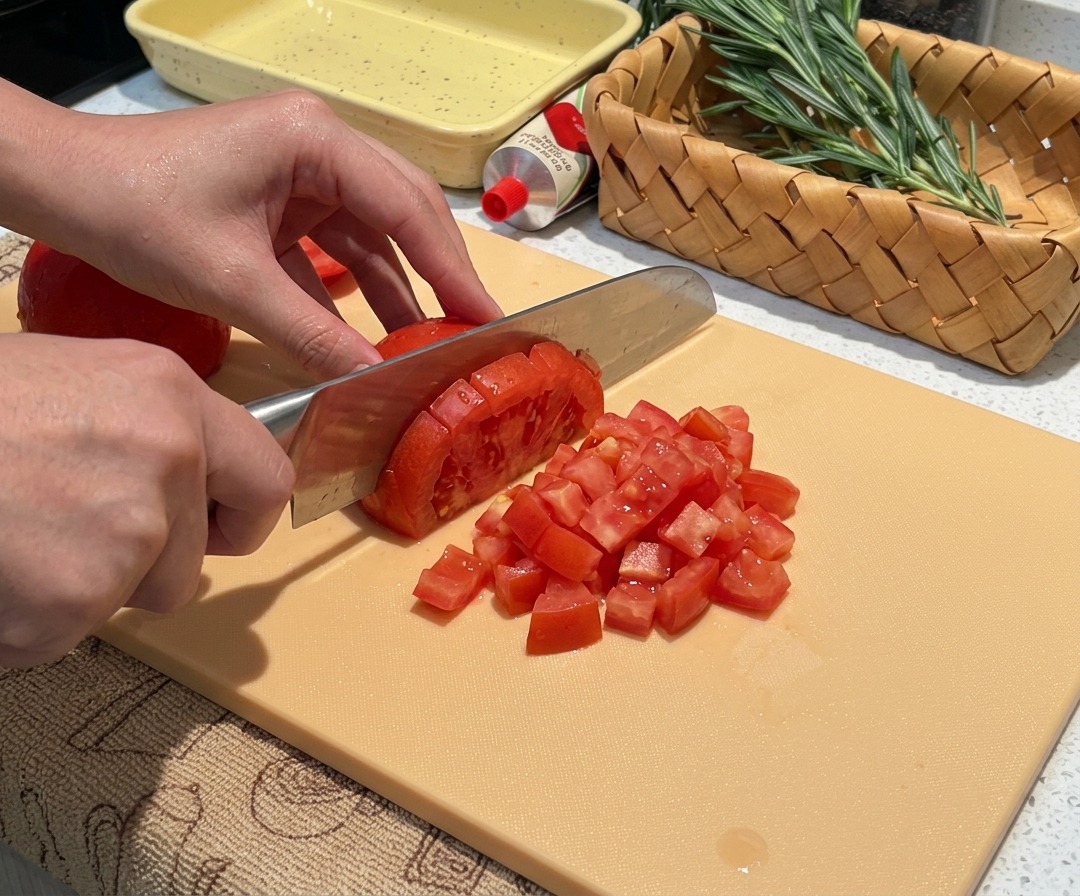 Pomodori pelati freschi tagliati a cubetti piccoli e uniformi.