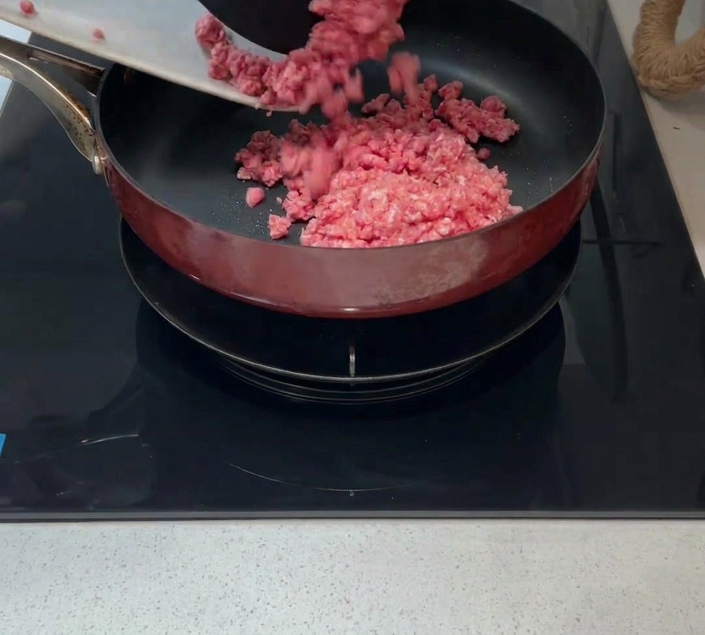 Macinato di carne crudo aggiunto in una padella calda con un filo dolio.