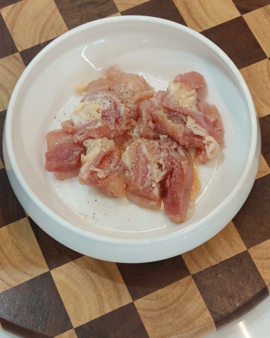 Ciotola con pezzi di pollo crudo conditi pronti per la padella.