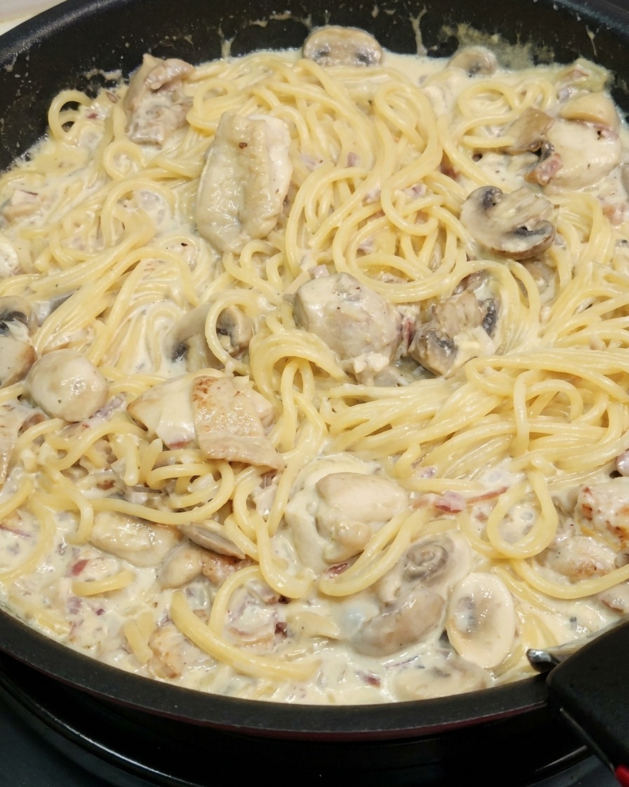 Spaghetti saltati nella salsa cremosa con pollo e funghi.
