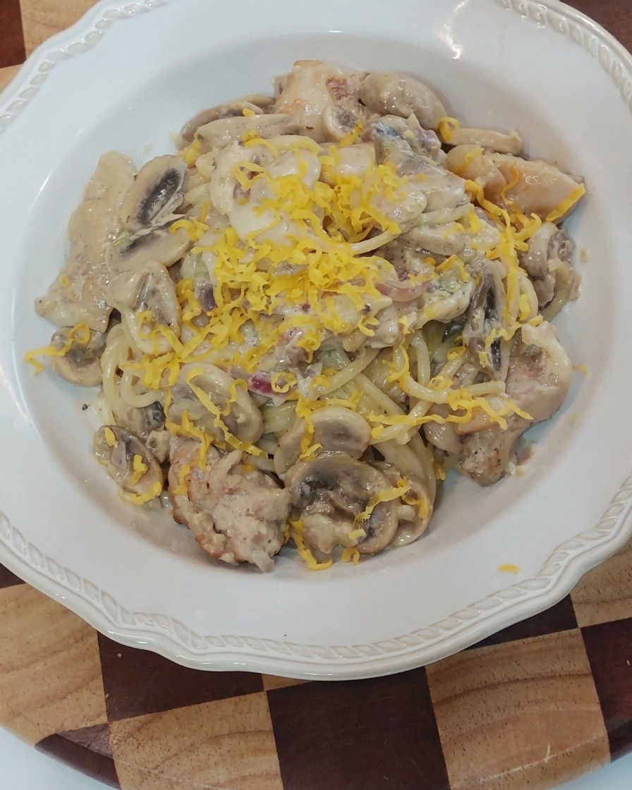 Formaggio grattugiato sopra la pasta cremosa.