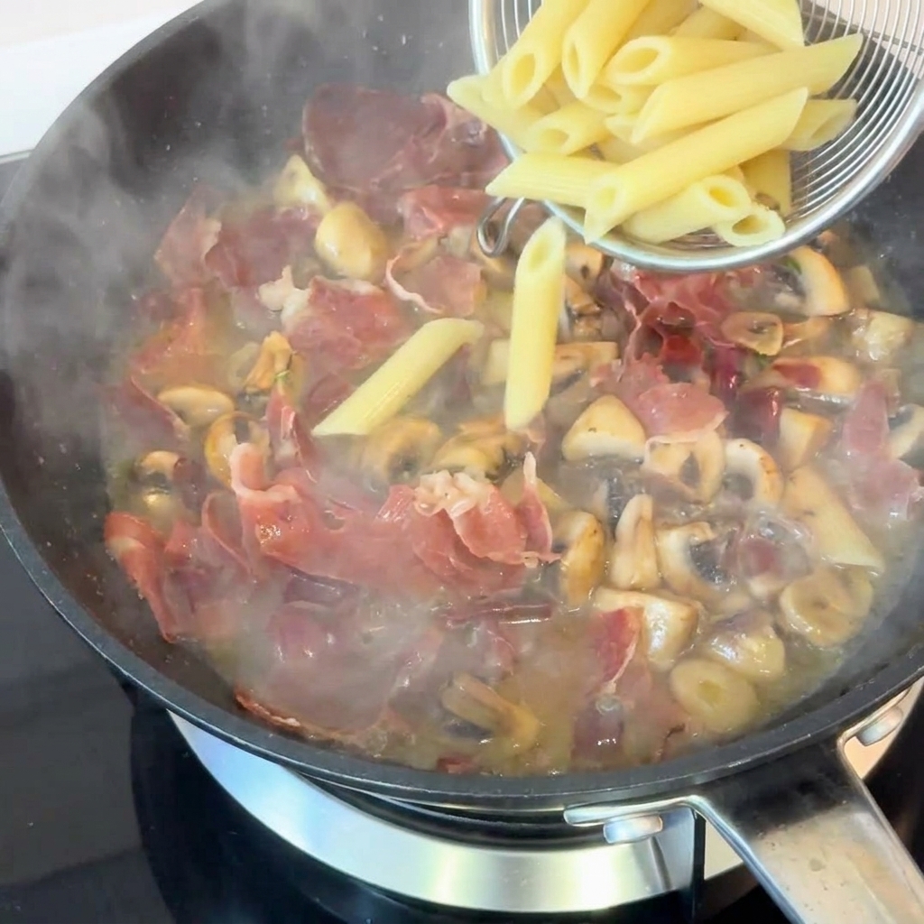 Penne cotte trasferite in padella con il condimento.
