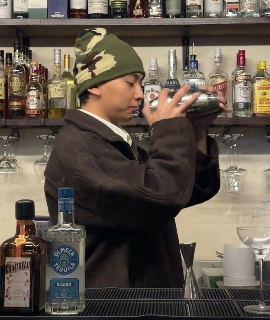 Un barman che agita vigorosamente uno shaker per raffreddare gli ingredienti.
