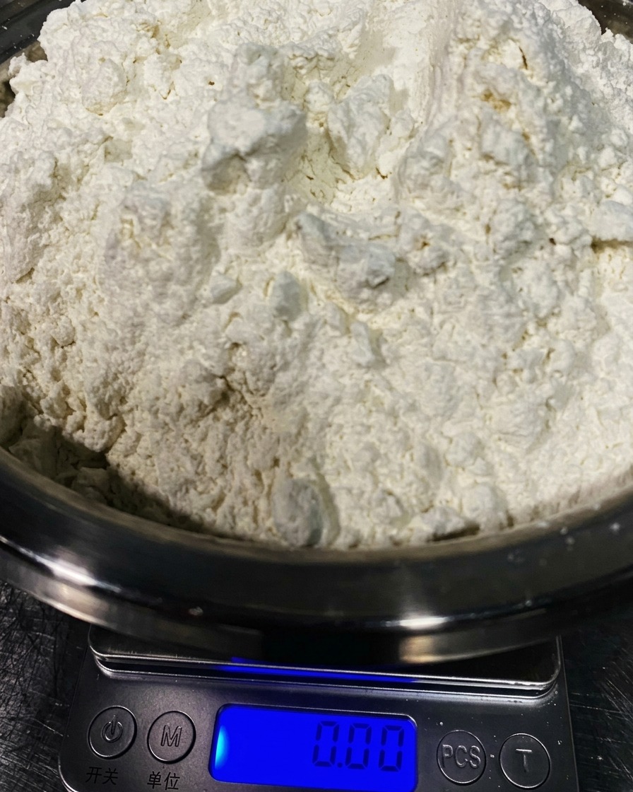 Farina 00 pesata in una ciotola dacciaio.