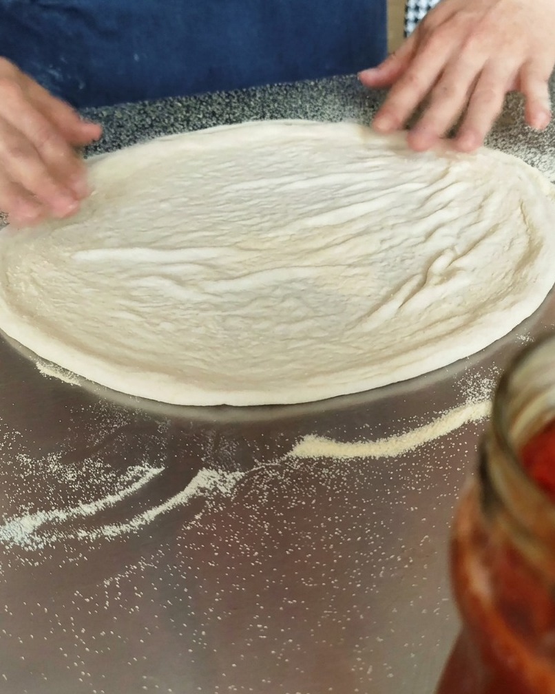 Disco di impasto su una superficie infarinata con semola.