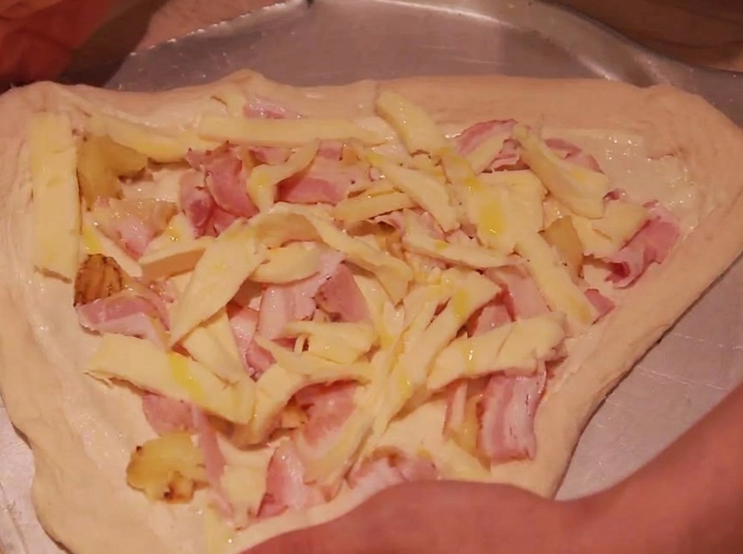 I bordi dellimpasto della pizza piegati verso linterno per racchiudere i condimenti.