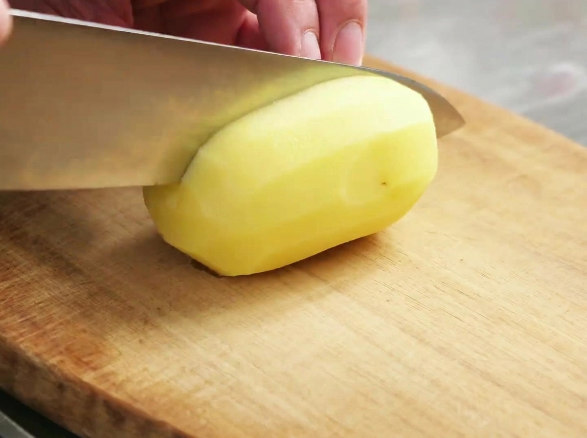 Tocchetti di patate crudi pronti sul tagliere.