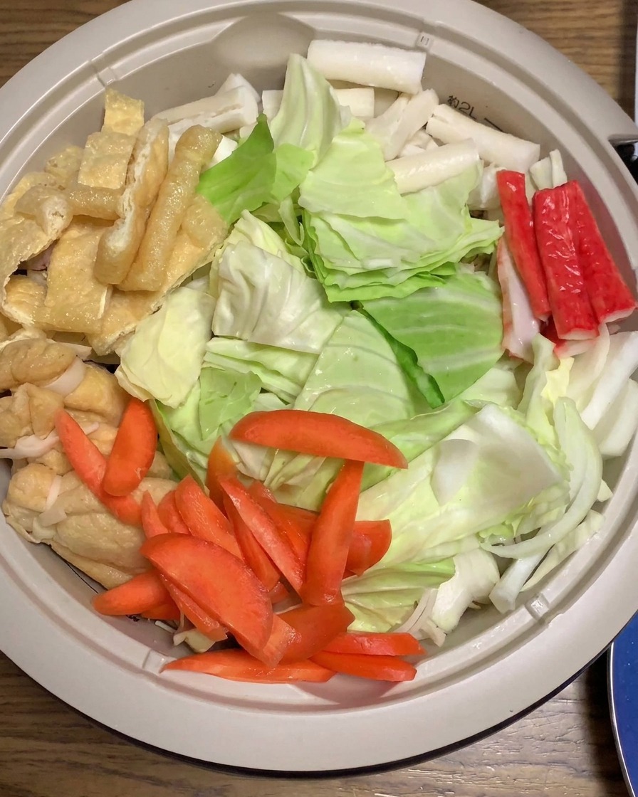 Salsa al miso versata sopra il cavolo, le carote e gli altri ingredienti stratificati in una grande pentola.