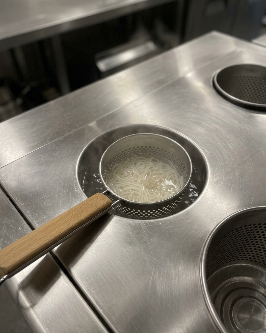 Noodles ramen cotti in una ciotola, pronti per laggiunta del brodo caldo.
