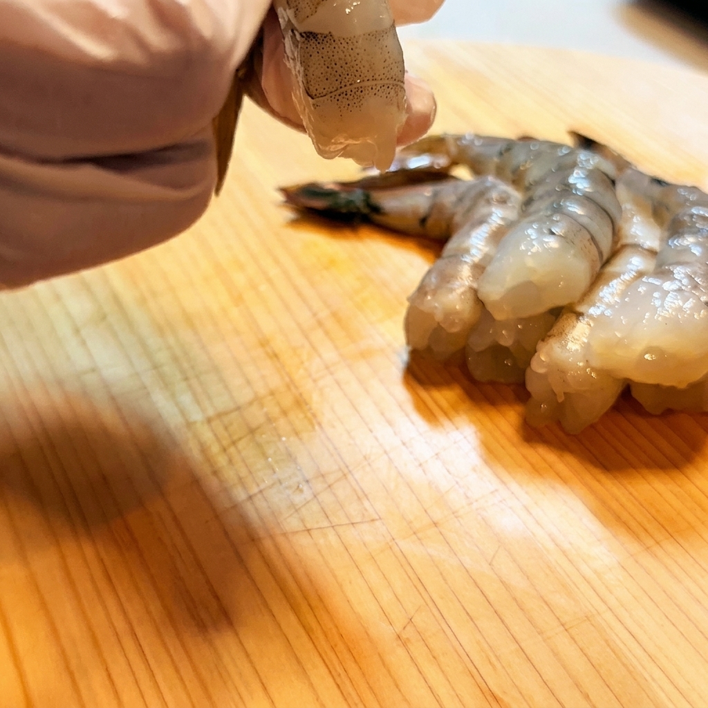 Gamberi incisi e raddrizzati con un coltello.