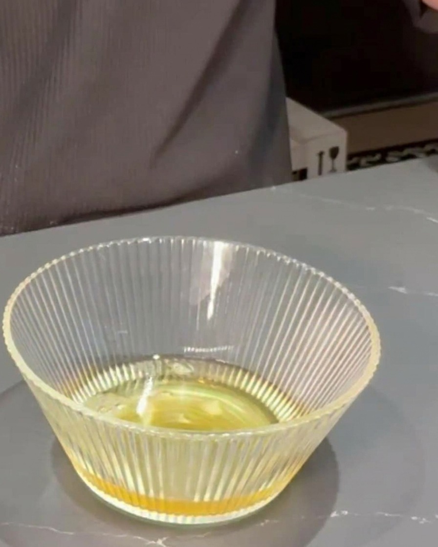 Mirin e salsa di soia versati in una ciotola di vetro contenente il brodo dashi.