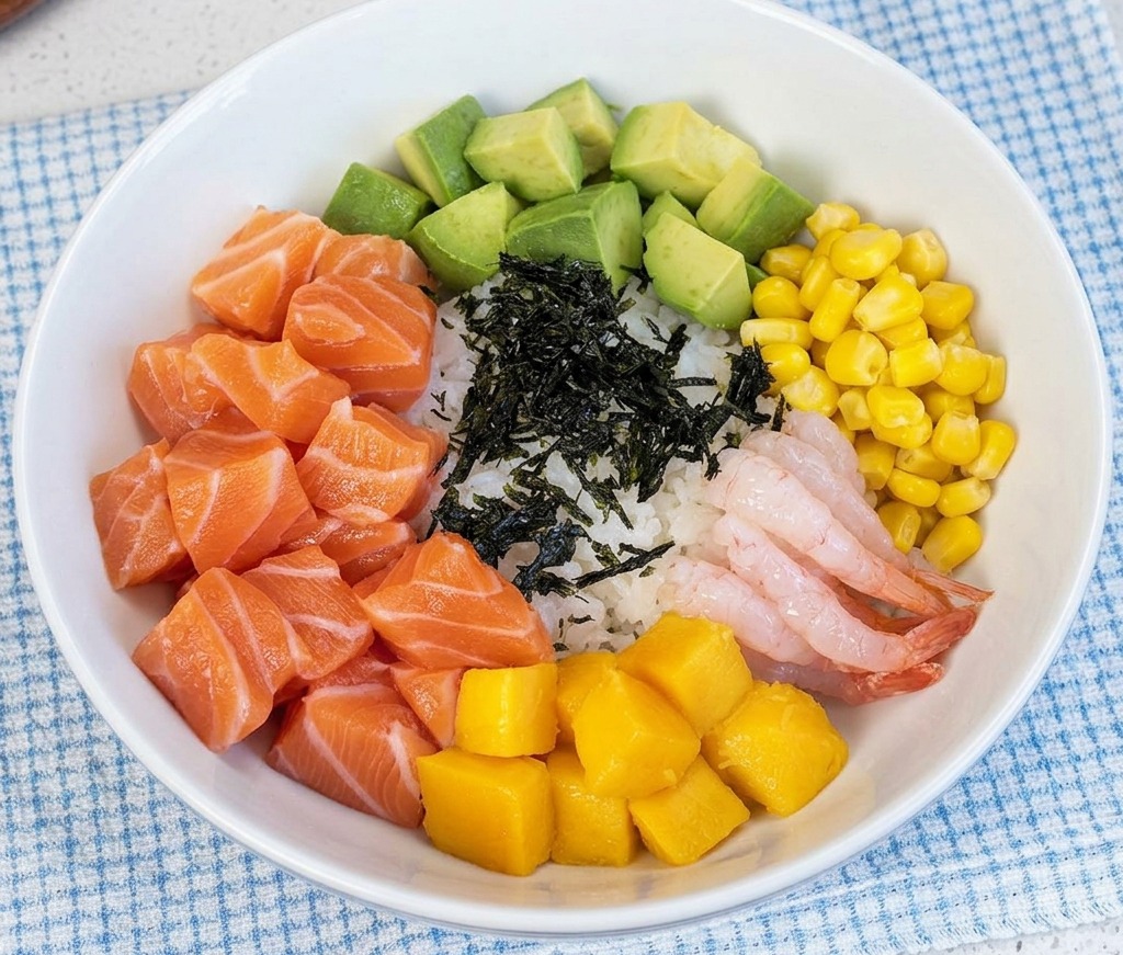 Sottili strisce di alga essiccata nera posizionate al centro di una poke bowl ricca di vari ingredienti colorati.