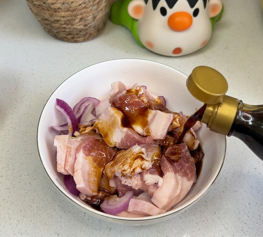 Condimenti liquidi scuri come salsa di soia e salsa dostriche versati sulla pancetta cruda e le cipolle in una ciotola.