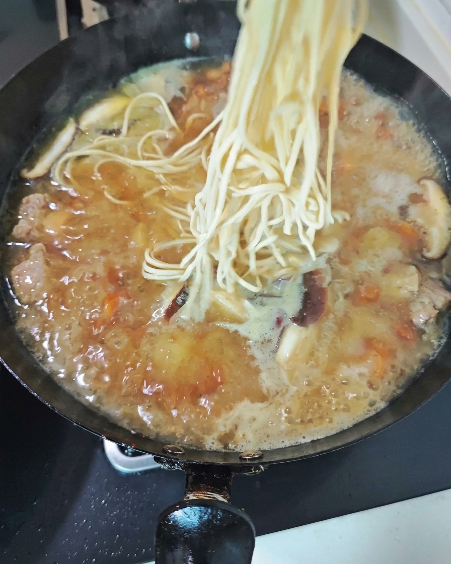 Una ciocca aggrovigliata di tagliolini di grano, tenui e pallidi, pronta per scivolare fra le bolle del brodo ricolmo di carne e di funghi affettati.