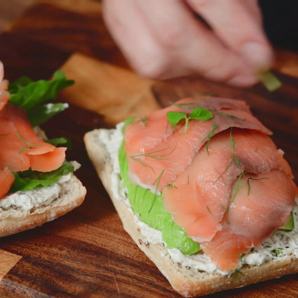 Fotografia macro di rametti di aneto fresco e piccoli microortaggi aggiunti come guarnizione sulla parte superiore di un panino al salmone affumicato.