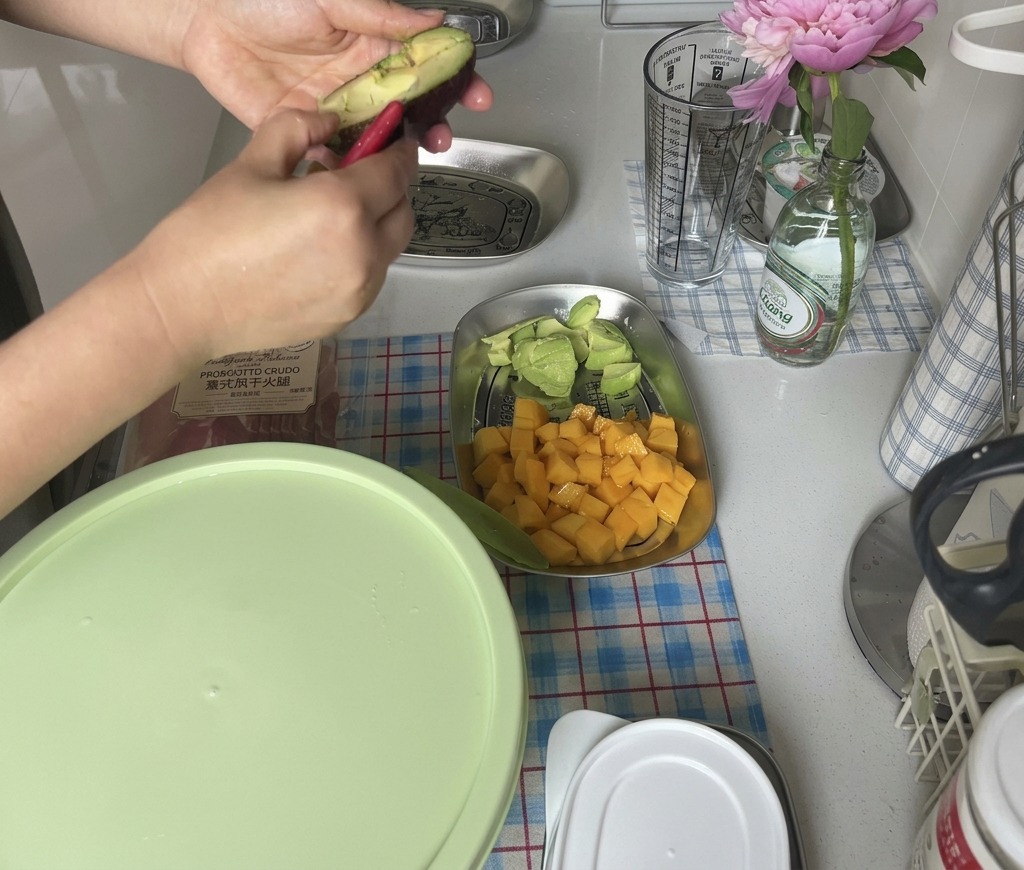 Mani che aprono un avocado maturo ruotando le due metà per accedere alla polpa.