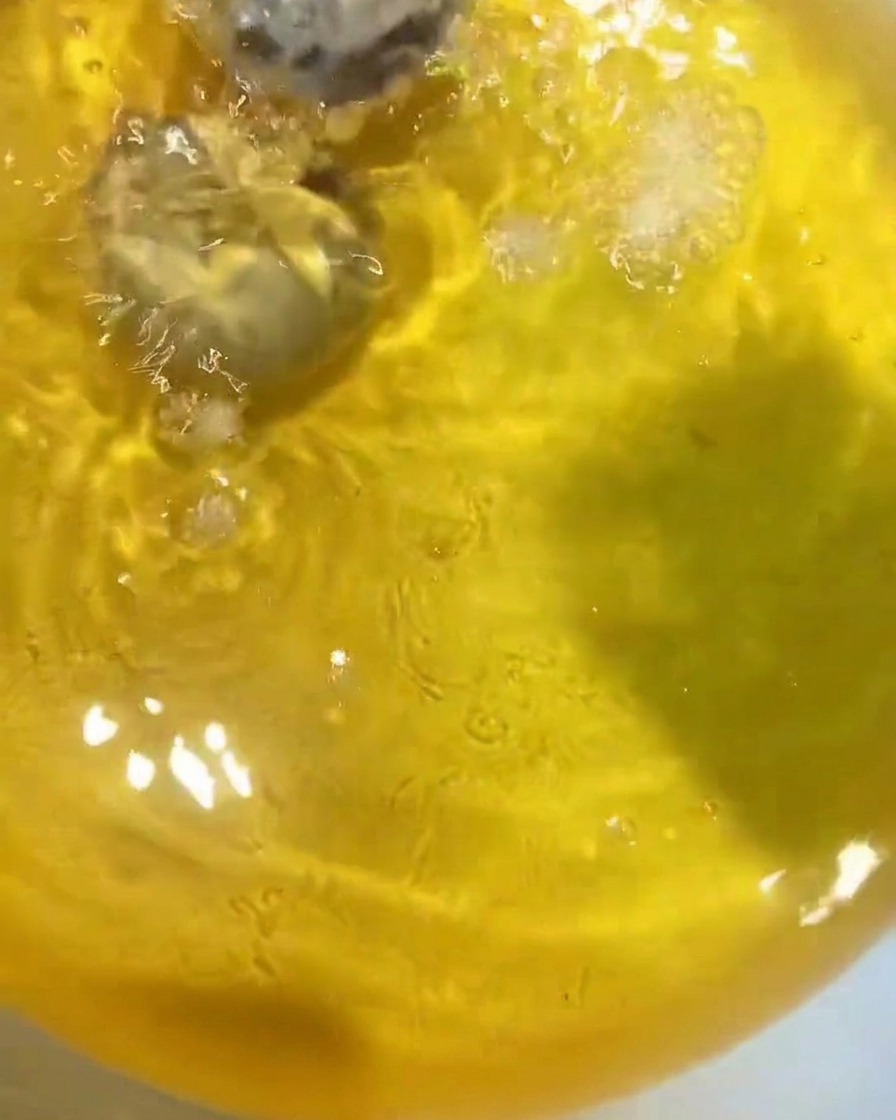 Gamberi e verdure che friggono nellolio bollente dorato.