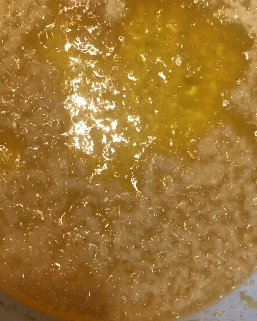 Briciole di pastella dorate raccolte dallolio caldo con un colino in metallo.