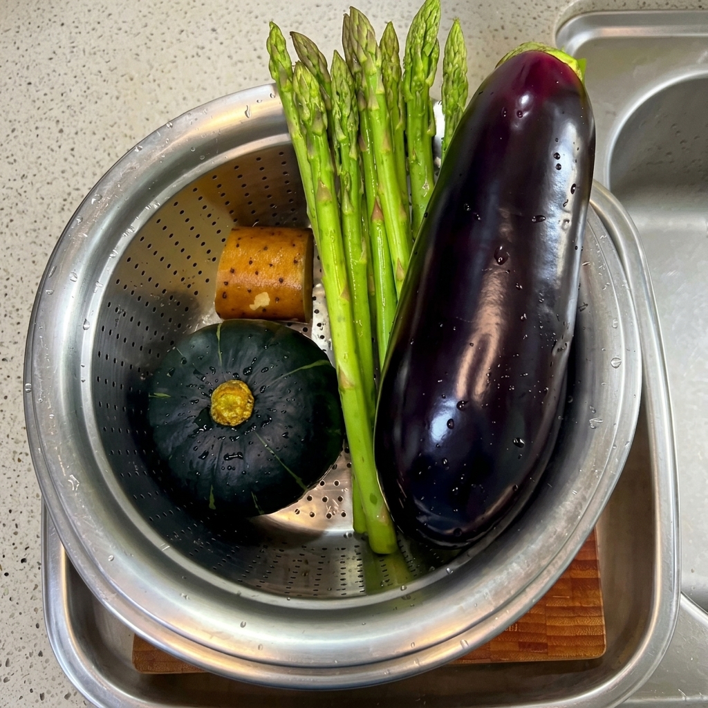 Asparagi, melanzane e pezzetti di zucca freschi lavati e pronti su un tagliere.