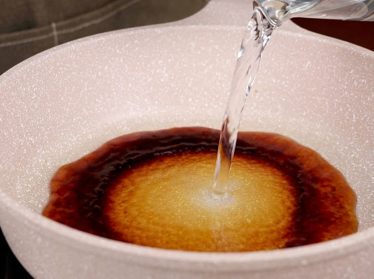 Acqua aggiunta a una padella con salsa teriyaki.