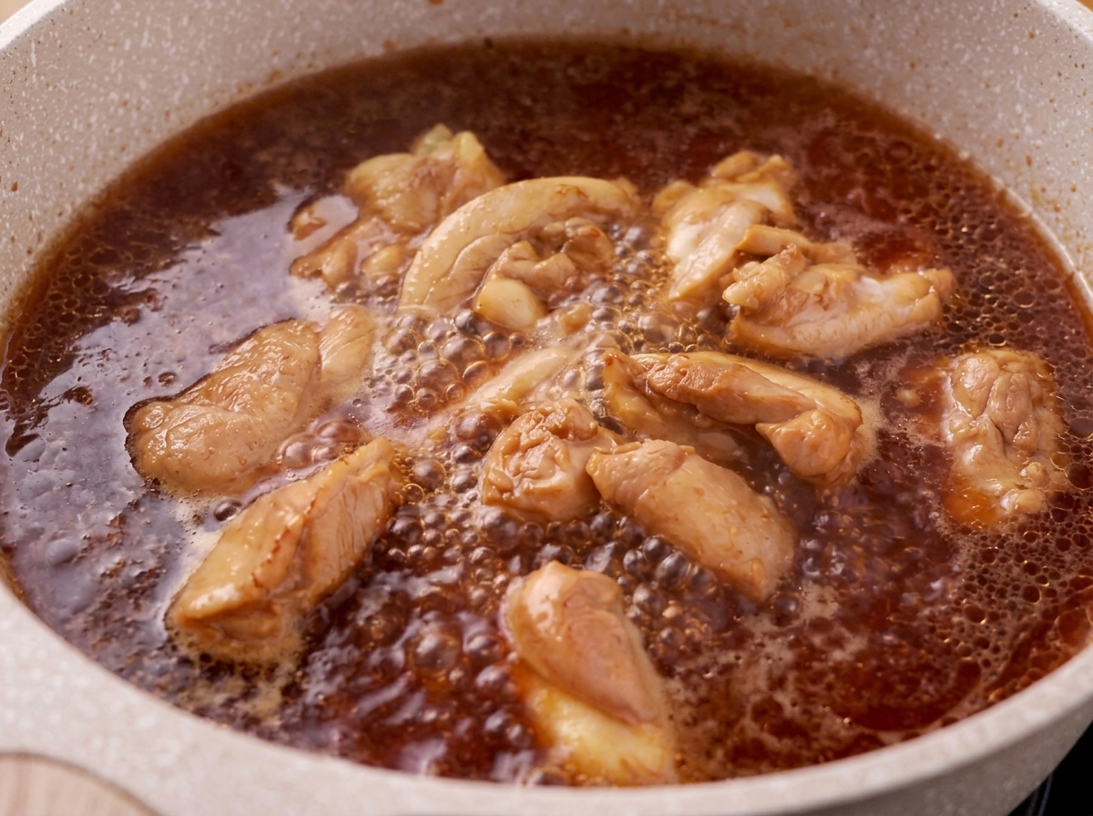 Rimozione della schiuma dalla superficie del brodo in ebollizione con pollo e salsa teriyaki.