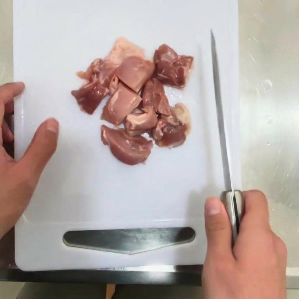 Una cipolla tagliata a strisce sottili su un tagliere.