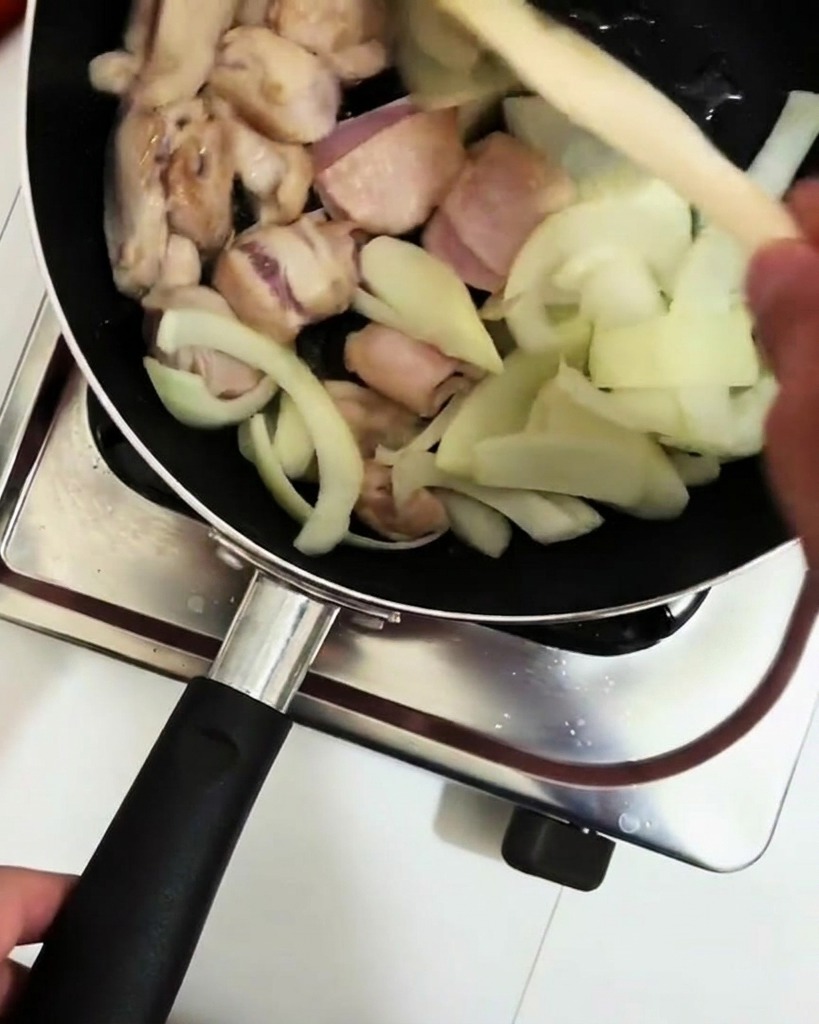 Vino da cucina versato con un mestolo nella padella.