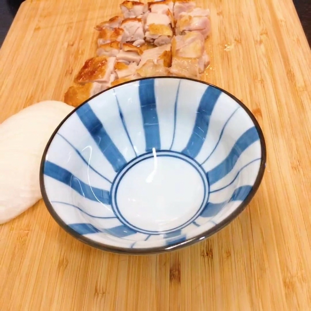 Mirin e salsa di soia mescolati in una ciotola a righe bianche e blu.