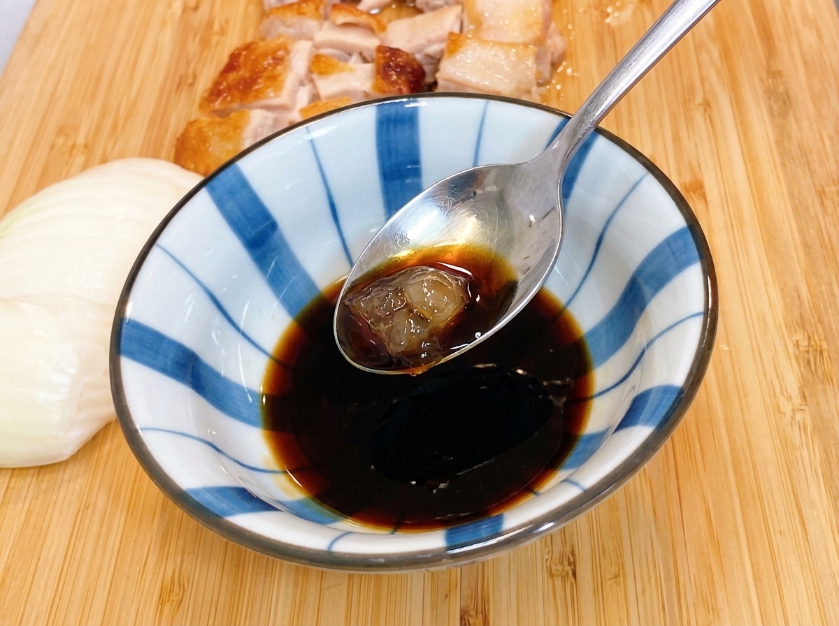 Una piccola padella di metallo su un fornello a gas contenente una pila ordinata di anelli di cipolla bianca cruda.