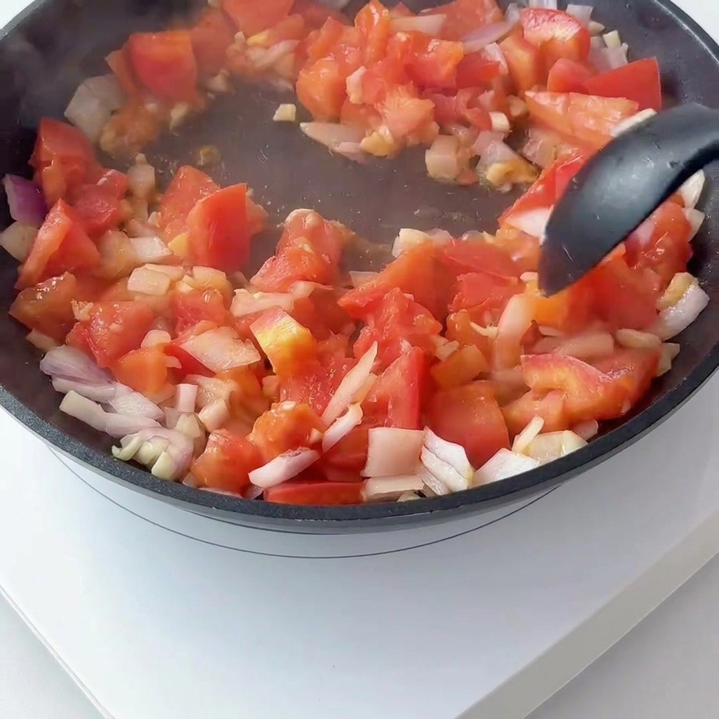 Pomodori a dadini e cipolla rossa saltati in padella e mescolati al concentrato di pomodoro.