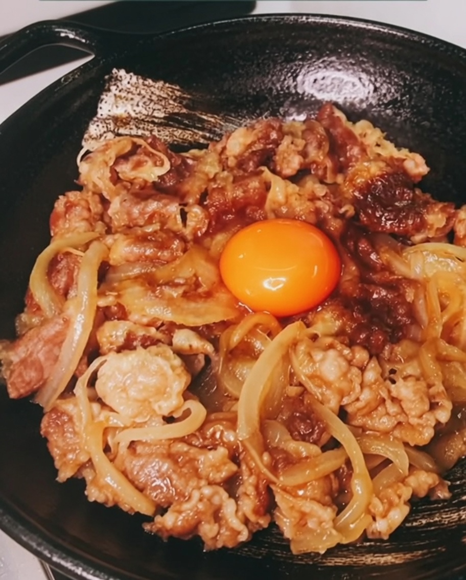 Tuorlo duovo fresco al centro della ciotola di gyudon.