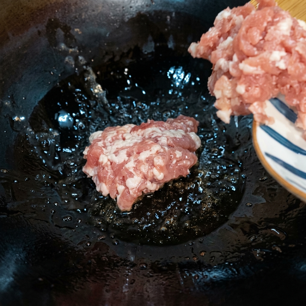 Carne macinata rosolata in un wok caldo a fuoco medio-basso finché non è ben dorata.