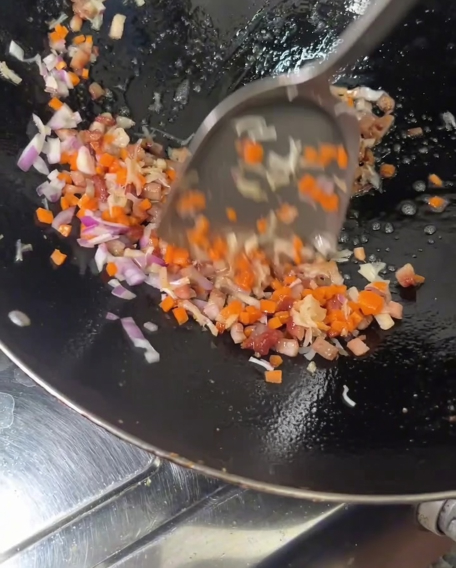 Aggiunta di carote e cipolla rossa nel wok con le carni.