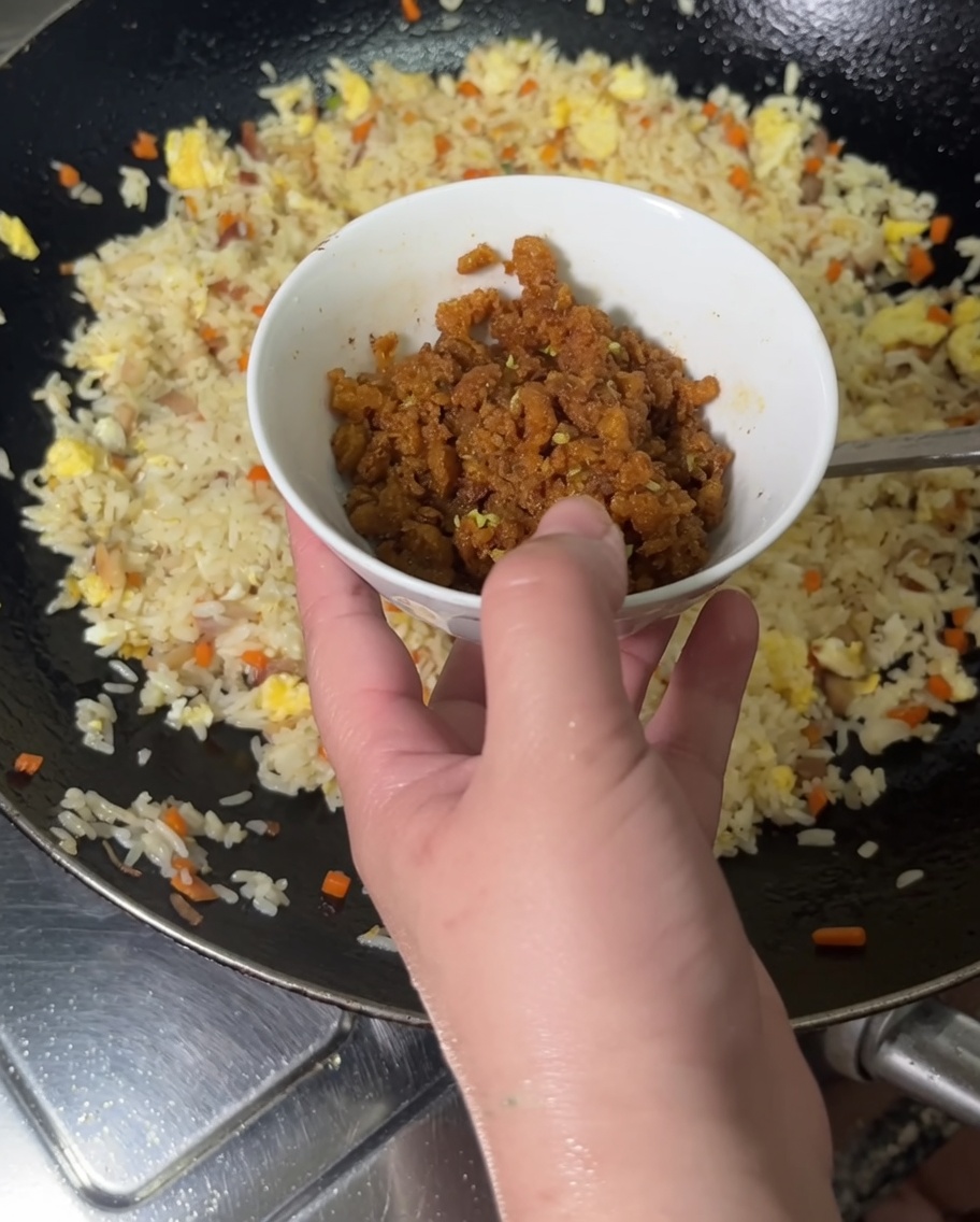 Versare i ricci di mare cotti nel wok con il riso fritto.