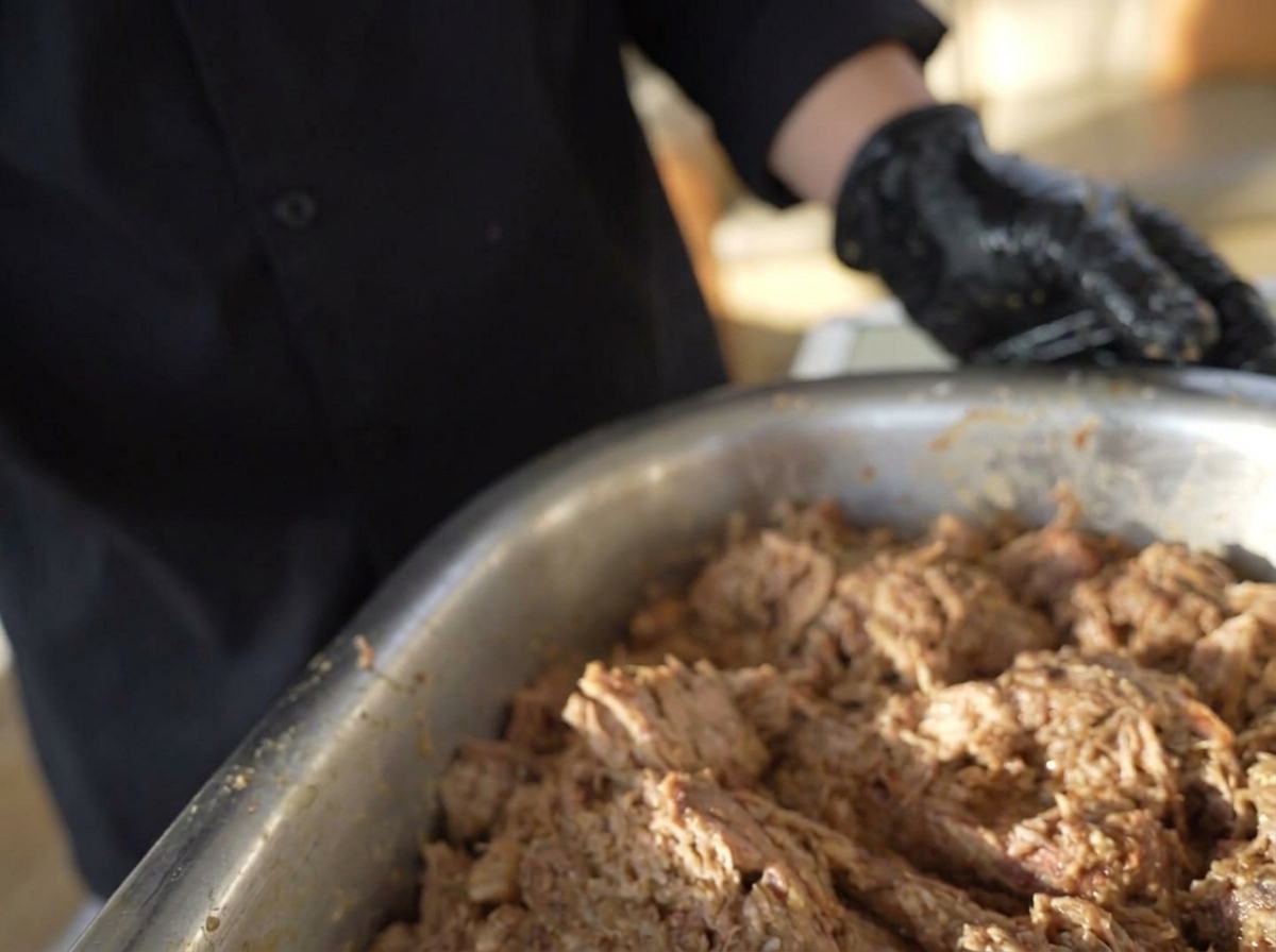 Mani che modellano il composto di carne marinata in polpette rotonde e spesse.