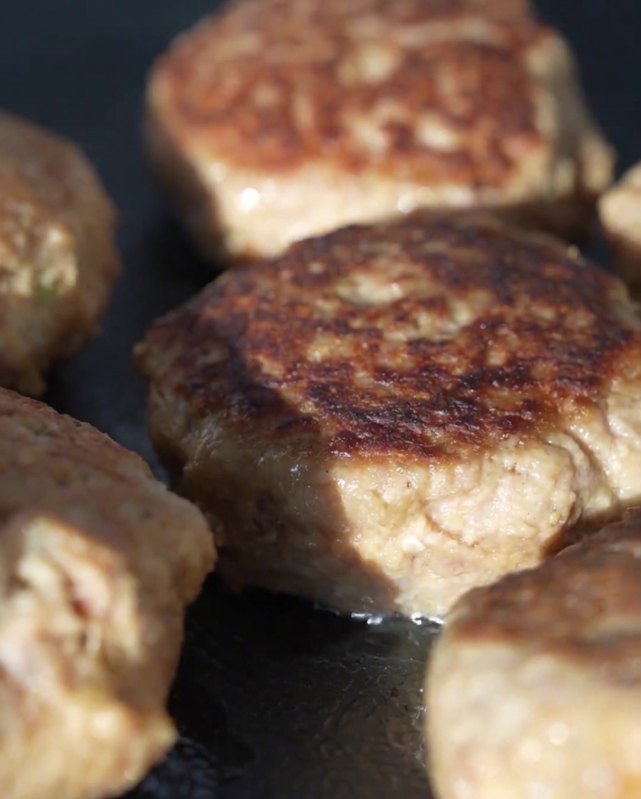 Coperchio in vetro che copre la padella con le polpette allinterno per cuocerle a vapore.